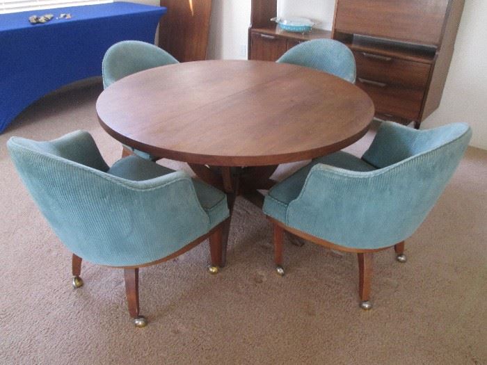 MCM Dining/Game Table with pedestal legs.  4-Barrel Chairs on casters and 2-24" leaves.  Table size: 48" Diameter.  Overall size with both leaves 96" X 48"