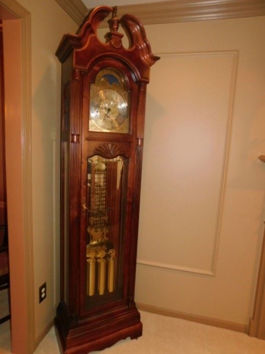 Howard Miller Grandfather Clock  86 inches Landsbury
This floor clock features an elegant, swan neck pediment with an overlay of crotch mahogany crowned with an applied shell.
