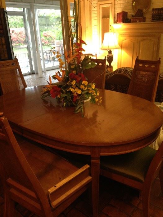 Oval dining table has 8 chairs and several leaves.