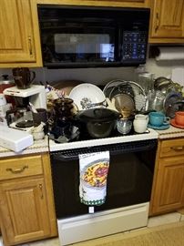 View of nice selection of cookware including Lodge covered pot, Corning Visions, Caphalon and Fiesta ware cup and suacers