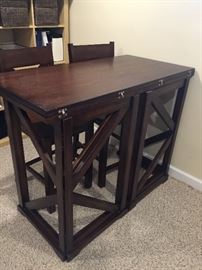 Great space saving table. Legs fold in and top flips over to conserve space. Has 4 counter height chairs.  Shown here with top flipped up.