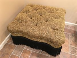 Fun tufted ottoman on casters with animal print chenille fabric, black fringe