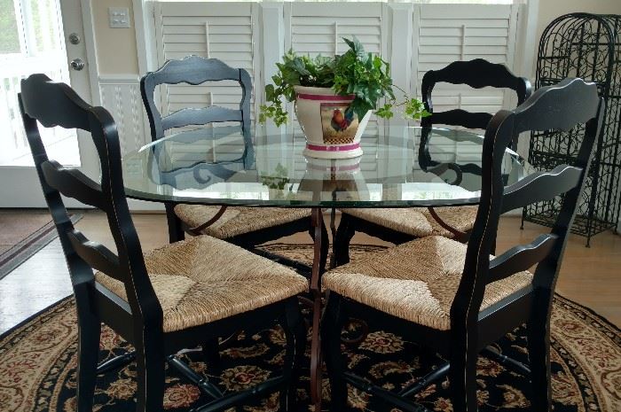 Glass dining table with black ladder back chairs