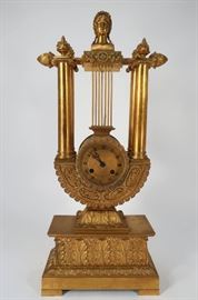 A Late 18th French Bronze Dore Mantle Clock, Lyre-Form Body surmounted by rod centered with classical bust, pairs of floral urns, terminating in Loti buds, works 8 day works