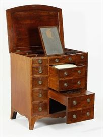 George III Mahogany Bow Front Gentleman's Dressing Chest of Drawers, c.1800 hinged top enclosing a fitted interior with apertures and lidded compartments centered by a ratcheted mirror, the front with three faux drawers above a central deep drawer, faced as two drawers, with circular bowl aperture and another sliding commode section faced as two drawers, flanked by four small drawers on each side, mirror probably associated  Provenance:ex Christies
