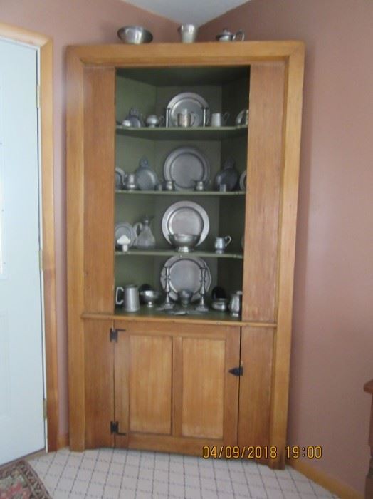 19th Century Pine corner cupboard. The lower section has room for storage while the upper section displays.  This cupboard has pewter from 1810-on  