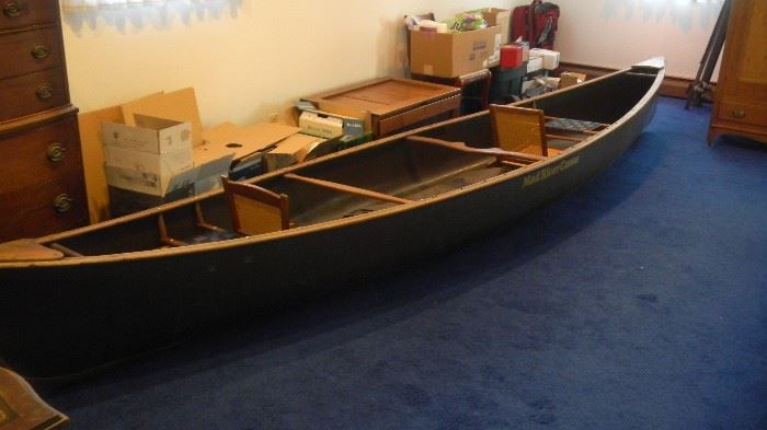 Mad River Canoe, 17' Duck Hunter model made of Royalex. They no longer make this material which was used in all whitewater canoes. The pads on the hull ( bow and stern) are made of kevlar. The stained and slotted northern ash rails are very hard to come by. The web seats are durable and the cane seat backs are comfortable. The carrying capacity is 1,200 lbs of gear/ people with 6" of freeboard. Owner oiled the rails and stored the canoe indoors. The scratches on the hull are cosmetic and not structural. Weighs only 72 pounds