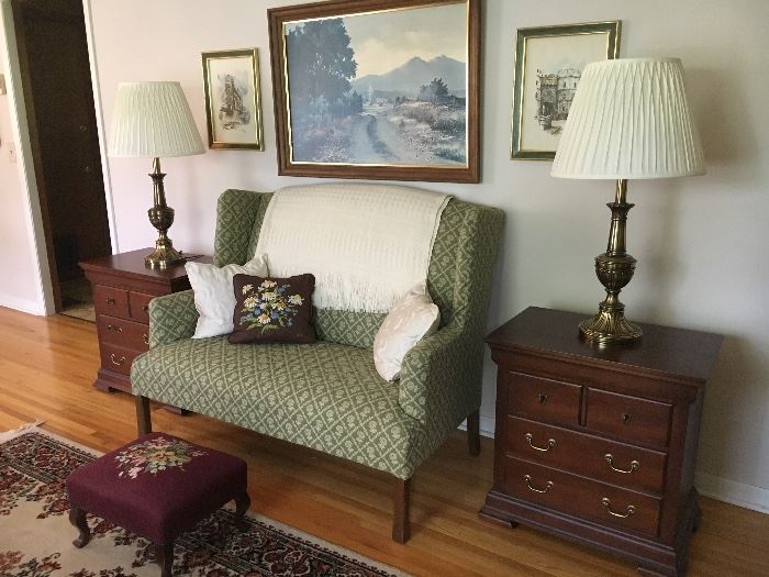 Sweet upholstered settee, pair of contemporary end tables by Pennsylvania House, Stiffel lamps and wall decor. Antique needlepoint footstool.