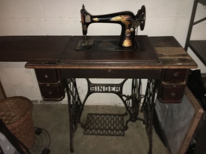 Antique Singer treadle sewing machine on original branded Singer metal base, includes side drawers.