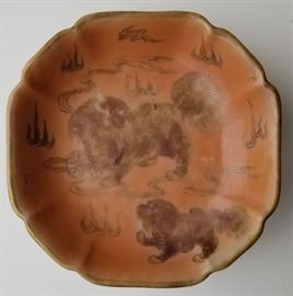 Signed Chinese Foo Dog Famille Rose Dish

Featuring a foo dog or lion in gilt on an orange glaze ground with underside enamel floral decoration. Lobed bowl or serving plate of pedestal form. Four character red box mark, wax export seal and modern paper label. Probably circa 19th century Qing.

5.5 inches across x 2 inches high.