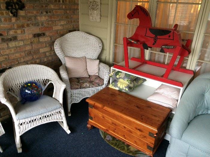 Wicker patio furniture; vintage rocking horse; cedar chest.