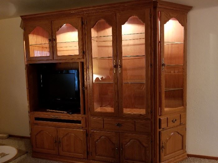 solid wood entertainment center with curio cabinets on each end,  Lighted glass