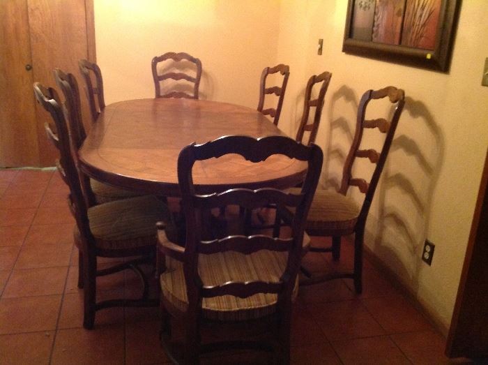 Century dining table and 8 chairs. Table has two leaves and can be reduced to a round table.