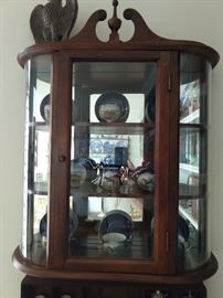 Close up of the vintage mahogany mirrored,  wall-mounted curio cabinet, with hand painted English porcelain tea set.