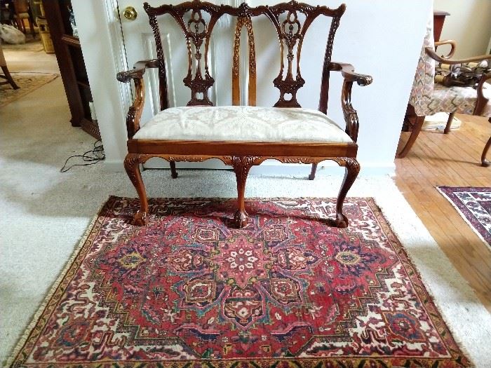 Mahogany Chippendale style settee, on a vintage Persian Heriz, measuring 3' 10" x 5'.