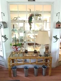 The screened porch has a fun collection of goodies to offer, like this bamboo console table with glass top, vintage French galvanized tin flower buckets, trailer trash galvanized tin birdhouse, vintage galvanized tin GA license plate birdhouse, pair of wall-crawling cast iron geckos - don't forget a vintage plaster Polly - she wants a cracker!