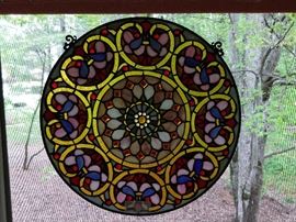One of a pair of round, stained glass windows.