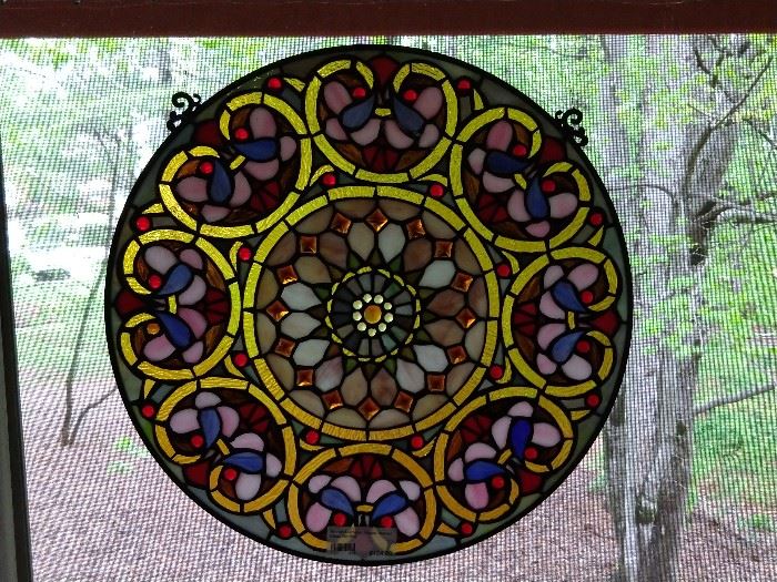 One of a pair of round, stained glass windows.