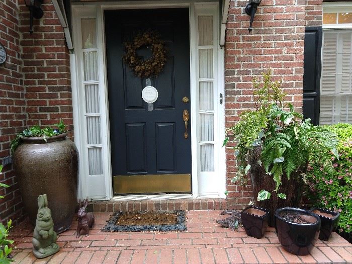 Front door with wreath, holding a bird's nest with four fledgling birds. I hope they'll be gone by the time we open the doors for the sale, but they've been fun to watch from eggs to birds! Pair of 4' tall glazed pottery urns, vintage concrete bunny, with good green patina, a pair of cast iron bunnies, and set of three black glazed terra cotta pots. 