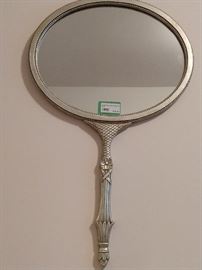 This is a vintage silver leafed wooden wall mirror, that looks like a giant hand-help mirror - cool & groovy!