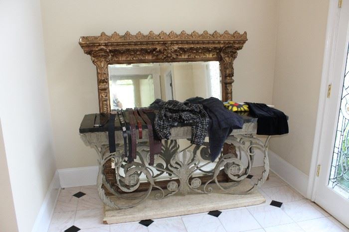 Hall table with elaborate iron work on base and marble top; huge gold-leaf mirror