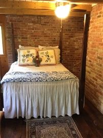 Poster bed, decorator pillows, linen spreads, etc. in an Anthropology style.