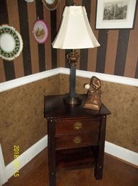 two-drawer table, lamp, decorative plates, artwork