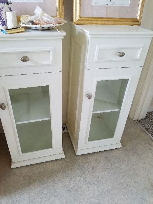 A pair of small white side tables