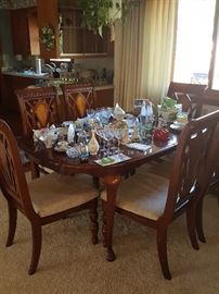 Beautiful dining room table with 6 chairs and 2 leaves; collectible pieces, glasses, trinkets.