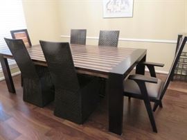 Reclaimed Brazilian peroba rosa dining table with two matching armchairs and four woven leather parson's style side chairs.