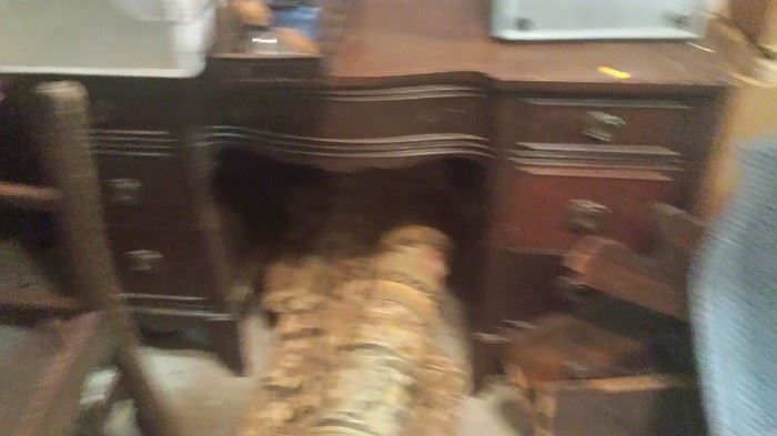blurry of mahogany desk with rug rolled underneath