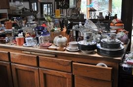 Plates and mugs and bowls and trays, glassware, canisters, serving pieces, kitchen utensils, microwave, platters, pitchers, sets of china, drawers full of utensils, sets of flatware