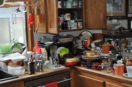 Plates and mugs and bowls and trays, glassware, canisters, serving pieces, kitchen utensils, microwave, platters, pitchers, sets of china, drawers full of utensils, sets of flatware