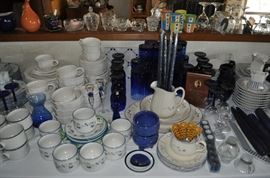 Several sets of china including Pfaltzgraff, a "ticking" pattern, blue floral, cobalt blue drinking glasses in two sizes, cobalt and clear wine glasses, cobalt blue wine glasses, beeswax candles, salt and pepper shakers