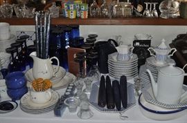 Several sets of china including Pfaltzgraff, a "ticking" pattern, blue floral, cobalt blue drinking glasses in two sizes, cobalt and clear wine glasses, cobalt blue wine glasses, beeswax candles, salt and pepper shakers, white tall pot