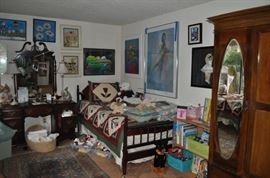 The girls' room... totally set up for her two adorable grandchildren.  That is an amazing antique Thomasville vanity with mirror, a pair of twin spool beds covered with quilts and other treasures... loads of art on the walls, an antique armoire, the best ever antique rocking chair, a spinet desk, and a trunk (antique) full of porcelain dolls.  Oh... and a closet full of more clothes, bedding, a corner etagere... and more stuff I can't remember!