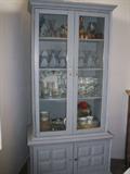 China cabinet full of glasses, serving dishes, china and collectibles.