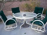 Round glass patio table with 4 swivel chairs.