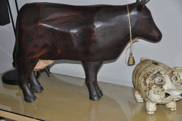 Large carved wooden cow shown with vintage ceramic signed pig bank
