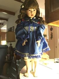 Vintage hand-poured and painted porcelain doll. Includes stand.