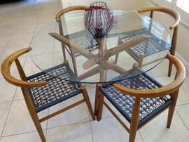Contemporary glass top table and woven seat chairs.