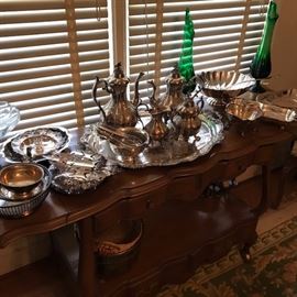 Lots of silver plate and vintage mid century glass on a White Furniture "Lorraine" rolling, flip top server.