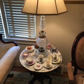 One of a pair of crystal lamps and marble top Victorian round side tables.  Complete with vintage cups and saucers.  Some are Occupied Japan.