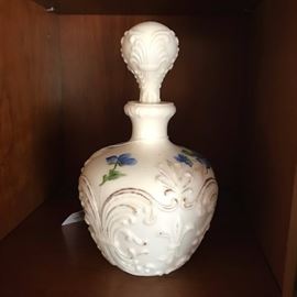 One of a pair of milk glass perfume bottles.