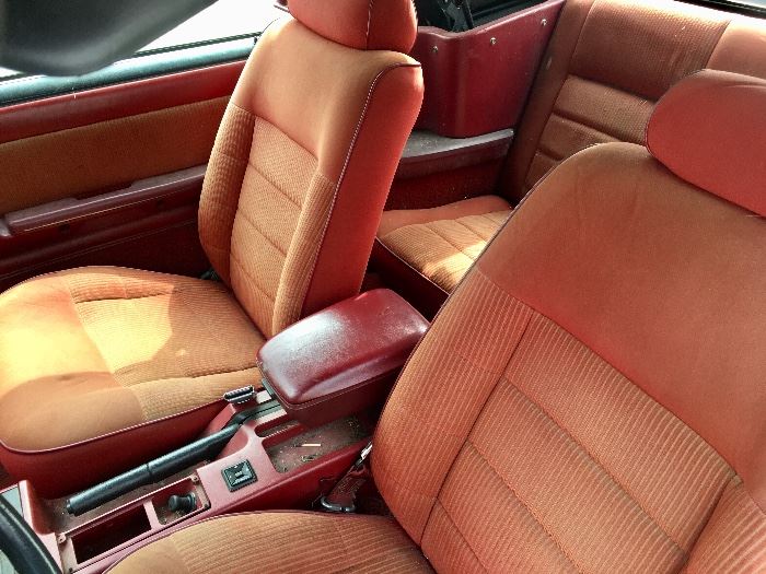 Front seat  of the Mustang, red interior. The yellow is the sunshining in, the seats are in very good condition.