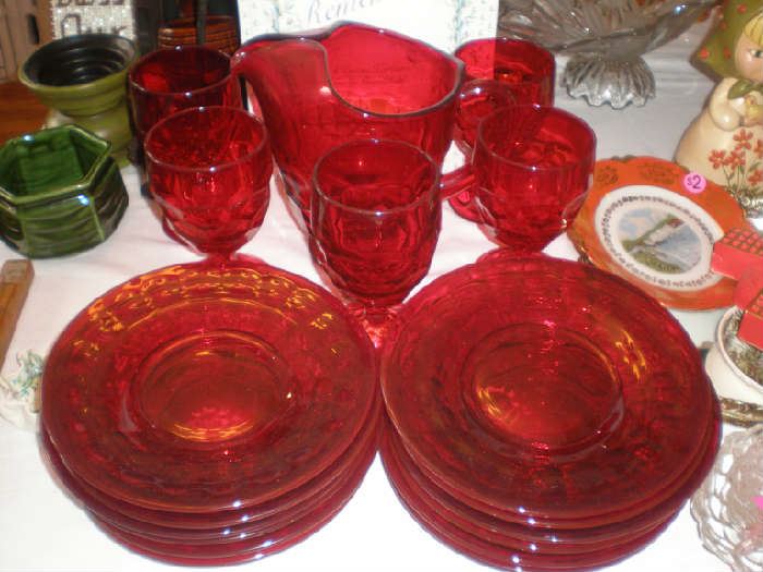 Close up of beautiful red glass, 12 plates, 5 goblets and a water pitcher, sold as a set.