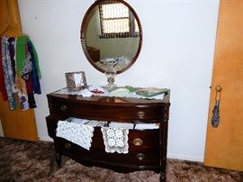 Overview of bedroom # 1, full-size bed with 2 dressers, clothing, hosiery and knitting/crochet items.