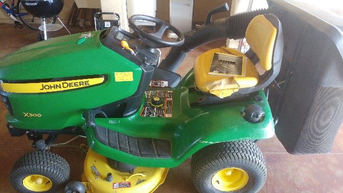 John Deere. X 300 riding mower with attachments and low hours.