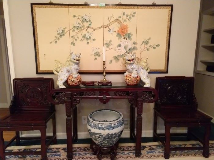 Hand painted 4-panel Chinese silk panel, gorgeous pair of porcelain foo dogs, heavily carved pair of Chinese chairs and matching console table, the rectangular scrolled top over a pierced geometric apron, on squared relief-carved legs joined by stretchers.