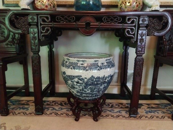 There are several of these Chinese porcelain fish bowls, three of the blue & white ilk. LOVE the carving of the Chinese mahogany console table, complete with glory hole in the middle.